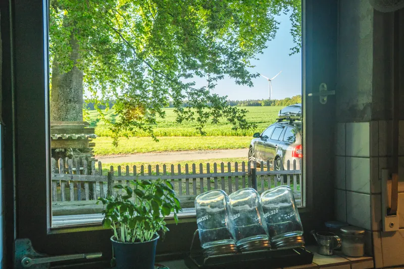 Küchenfenster mit Blick auf Felder und Windrad in der Ferne