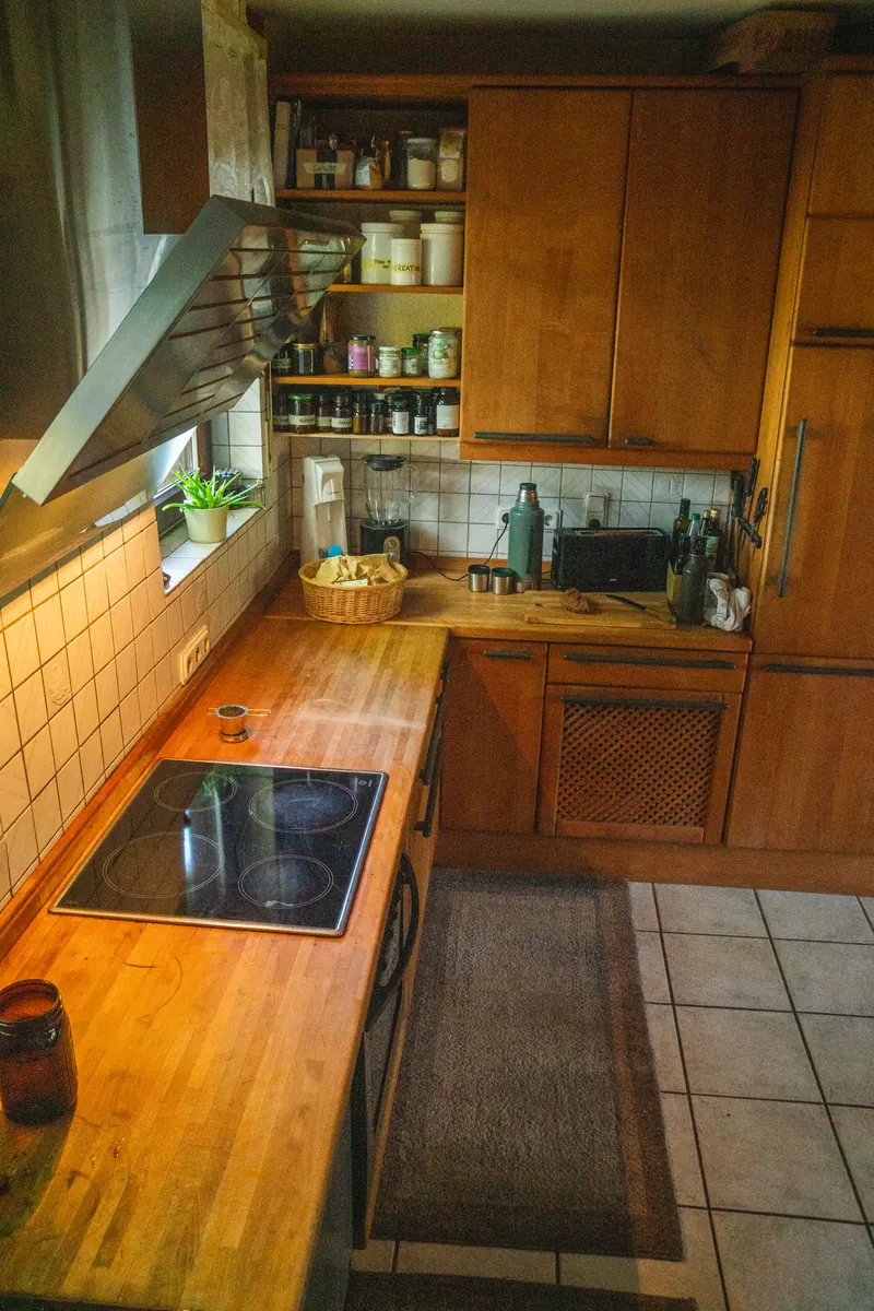 Küche mit Glaskeramik-Kochfeld und Vorratsschrank
