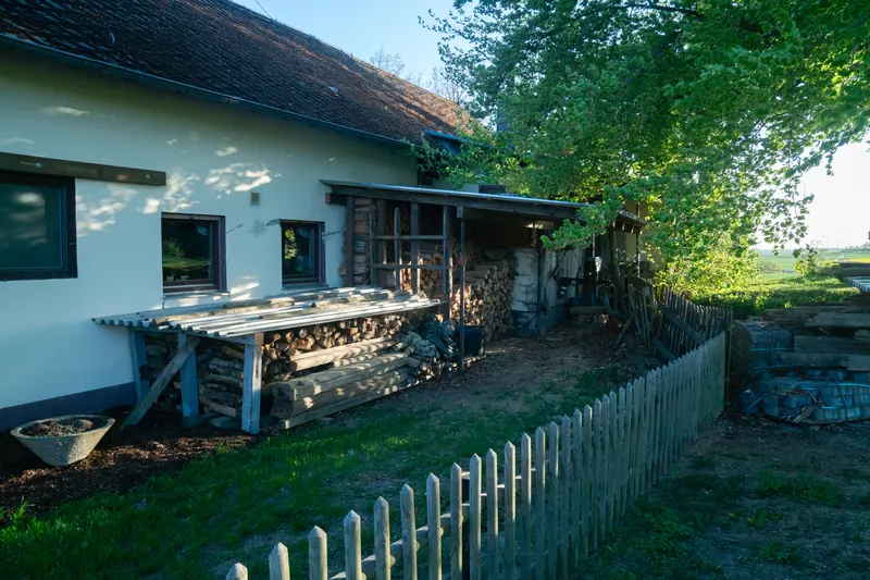 Nordseite des Hauses mit gestapelter Holzlagerung